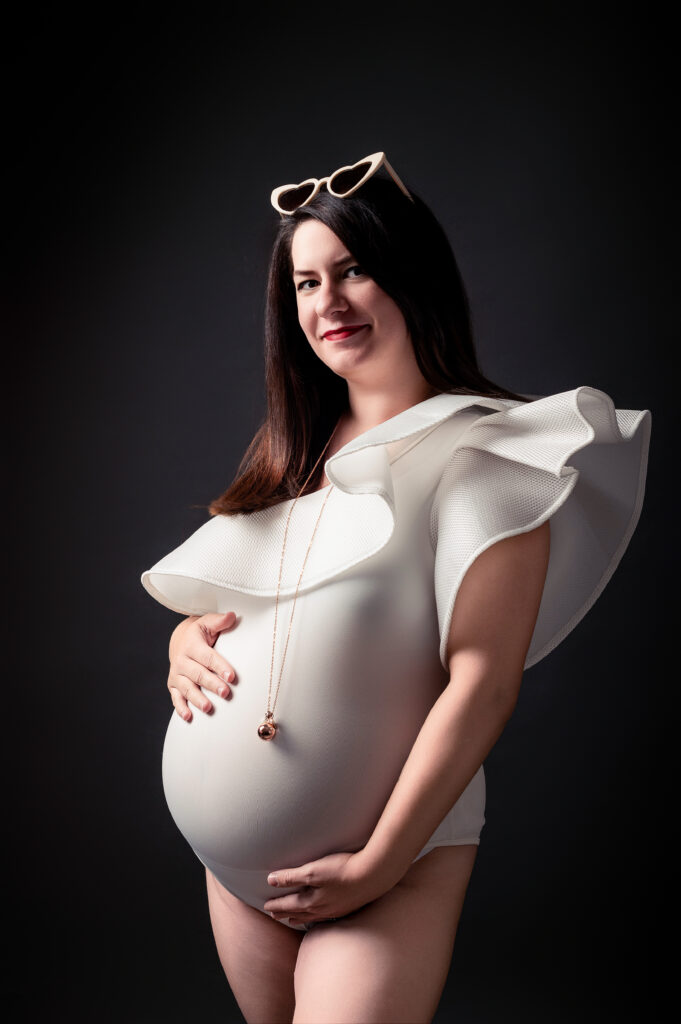 Future maman en body blanche, main sur ventre,