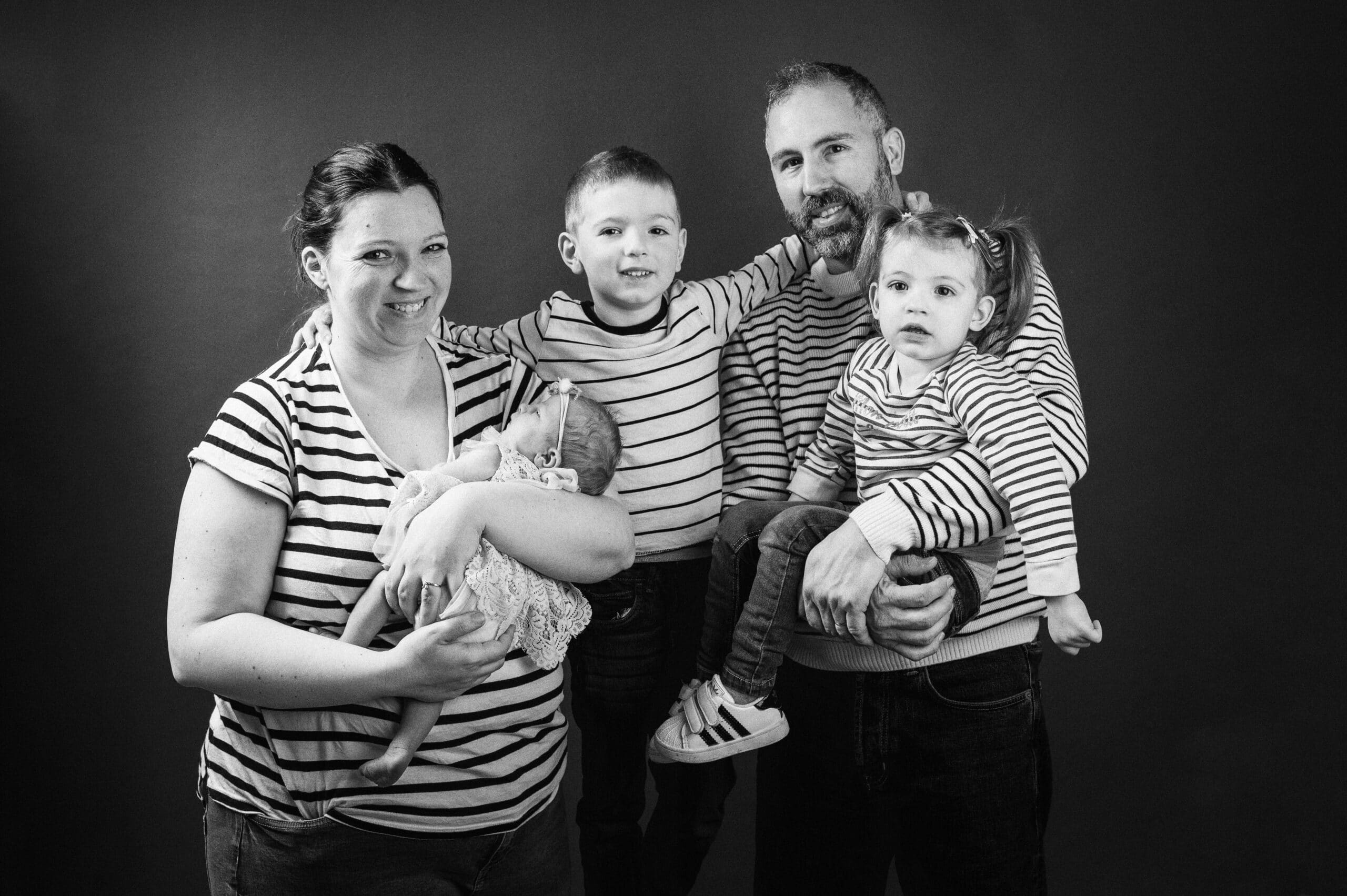 portrait de famille en studio avec 3 enfant pull marine et noir et blanc